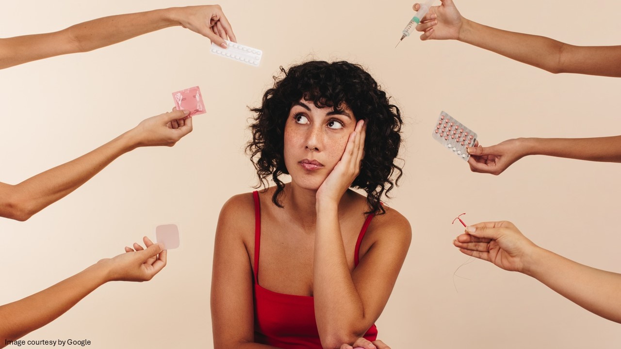 Many hands holding birth control products