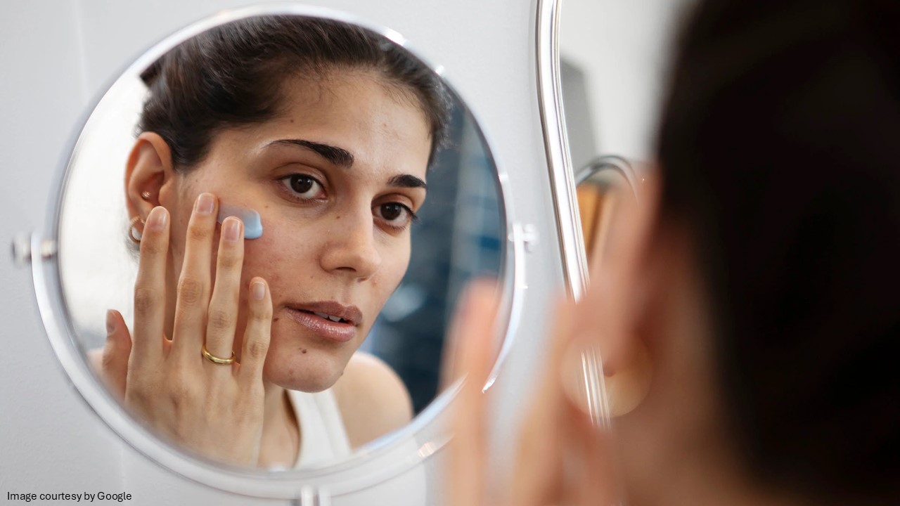 A girl looking at the mirror while applying the cream