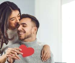 A couple holding a paper red heart