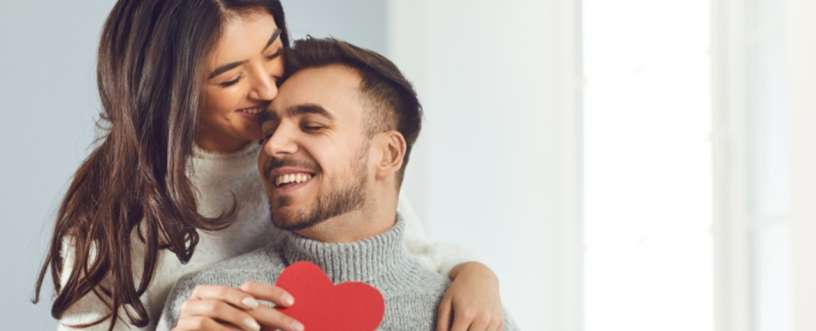 A couple holding a paper red heart