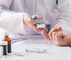 Doctor checking patient's blood sugar levels using a glucometer alongside diabetes medications, emphasizing safe management through medical care and treatment.