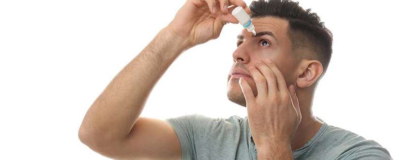 Man applying eye drops symbolizing Careprost eyelash serum use; compare best eyelash growth serums like Latisse vs Careprost.